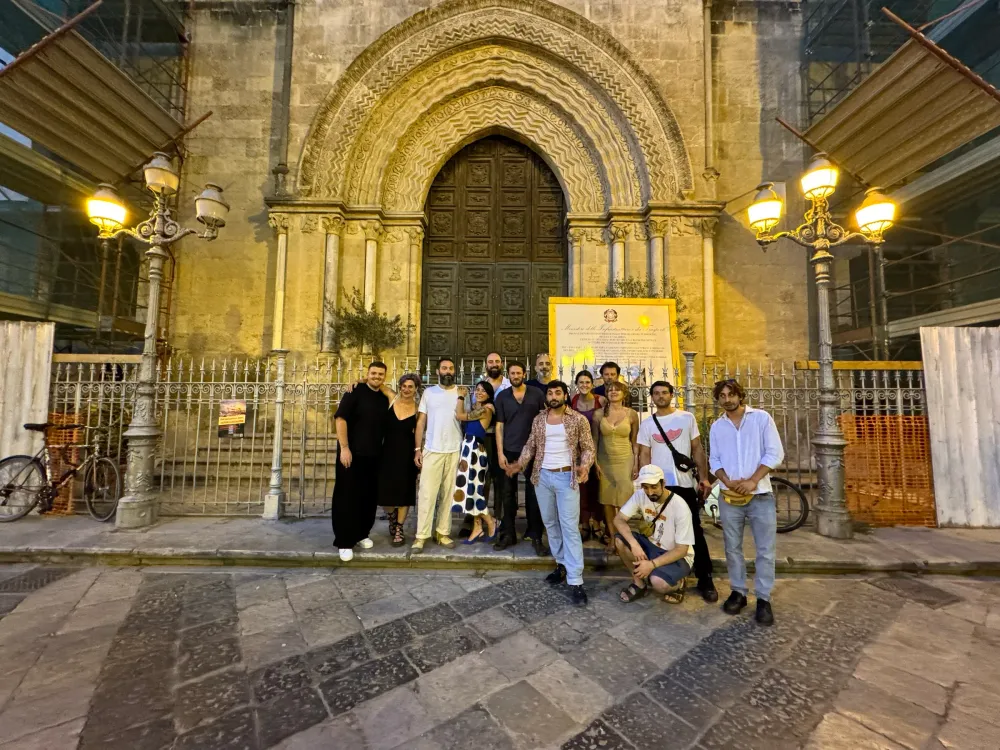 Foto di gruppo serale davanti al portale gotico di una chiesa
