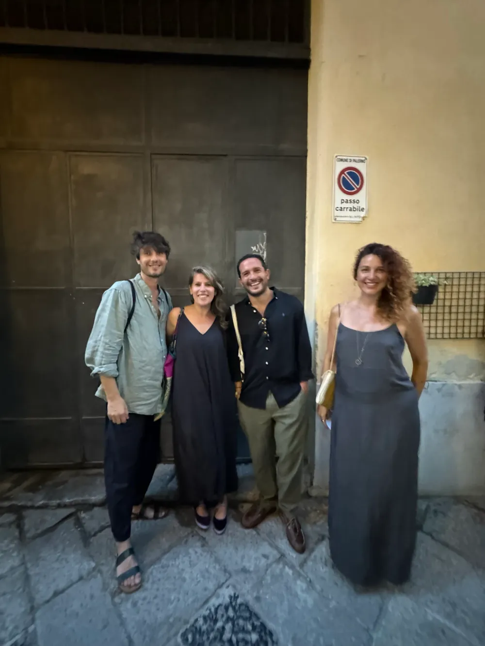 Quattro persone in posa davanti a un portone in via Maletto