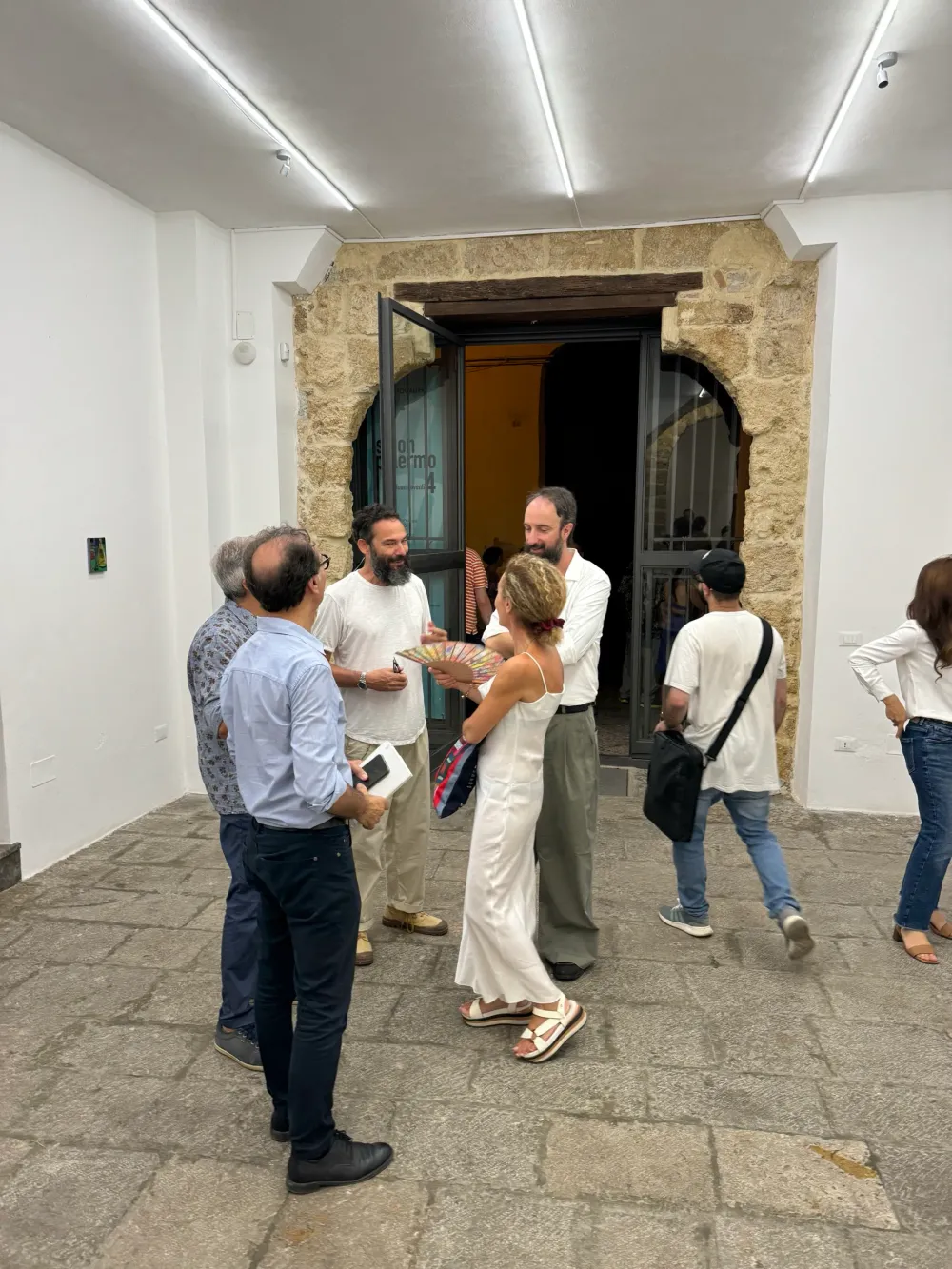 Visitatori nella prima sala, con il portone d'ingresso aperto sullo sfondo