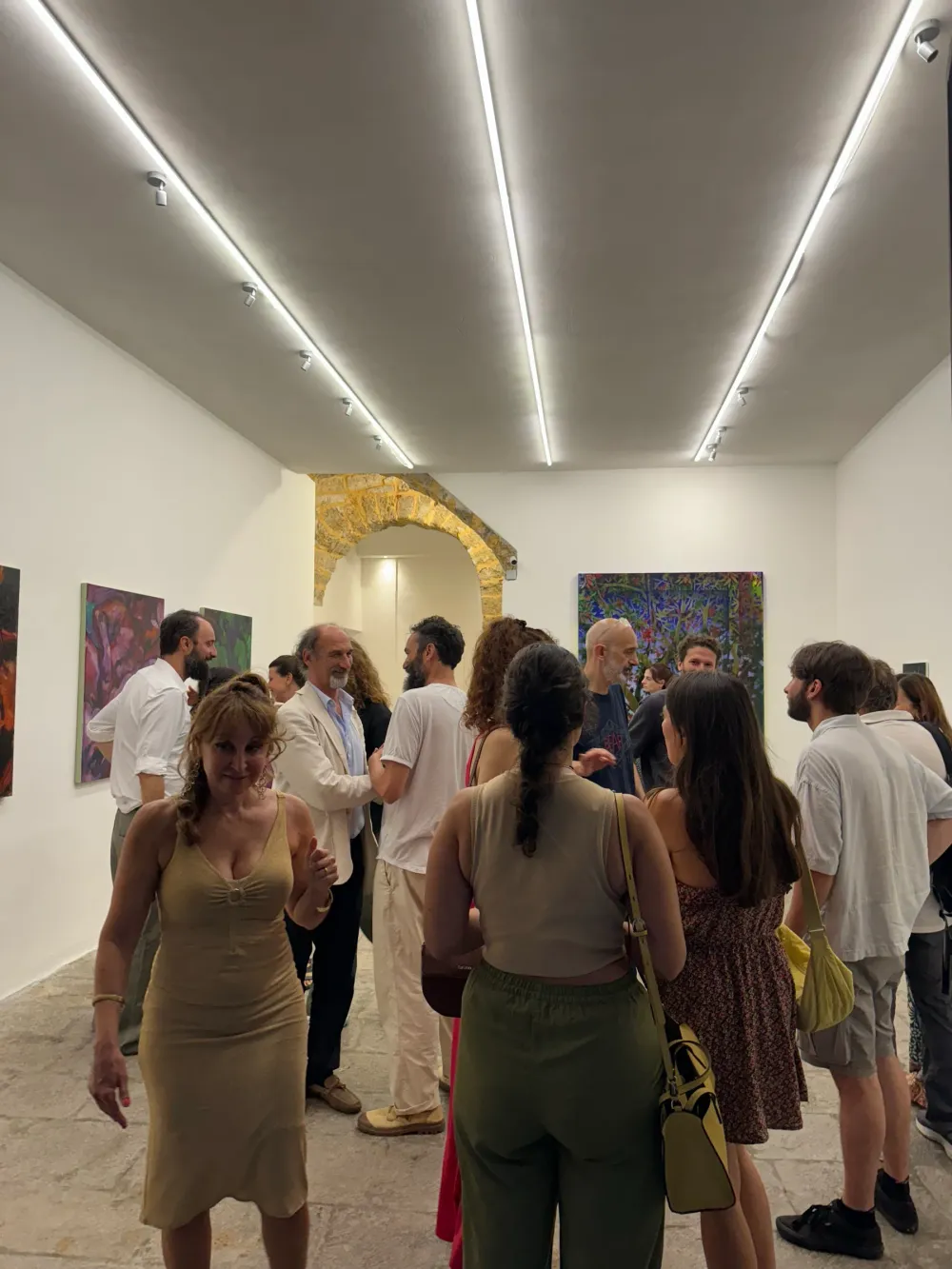 Visitatori nella sala lunga illuminata, a sera