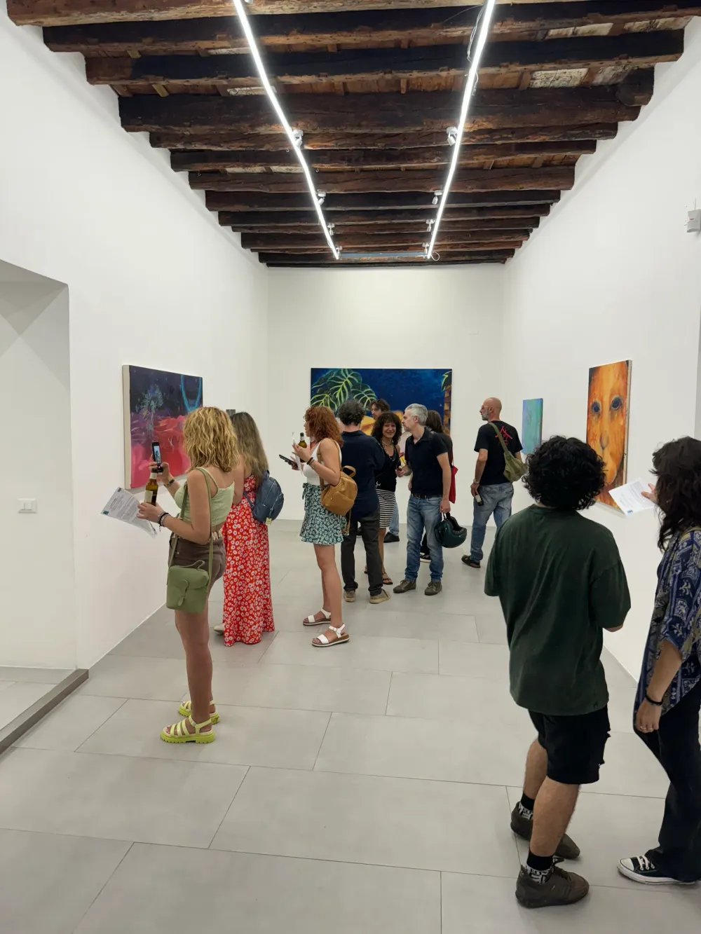 La sala con le travi di legno affollata durante l'opening